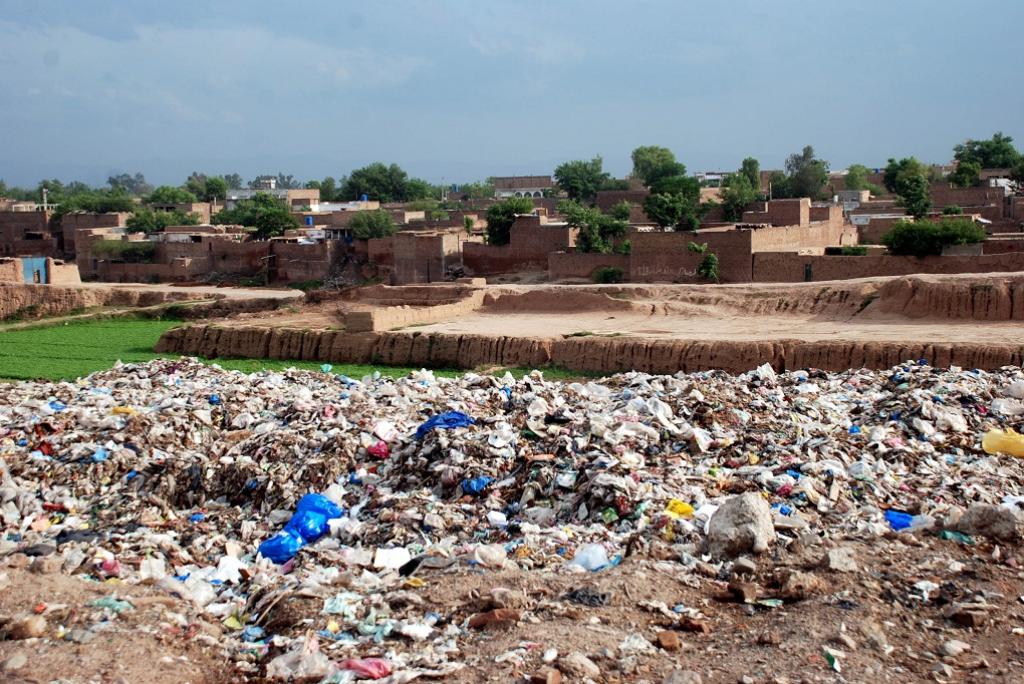 A view of solid waste near the populated area of Aftab Abad in Peshawar. Besides creating nuisance and a bad stink for locals, the leachate produced from the dump also affects agricultural land. Credit: Adeel Saeed