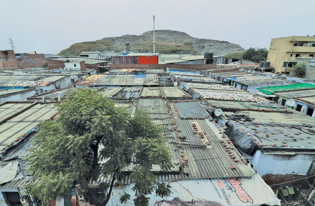 कचरे के पहाड़ के साथ लगा गांव पिराना कचरे के पहाड़ के साथ लगा गांव पिराना